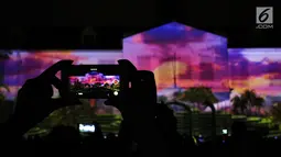 Warga mengabadikan pertunjukan projection mapping di depan area Museum Fatahillah, Jakarta, Jumat (19/1). Pertunjukan ini menandai rangkaian kegiatan perayaan 60 tahun hubungan diplomatik Indonesia-Jepang. (Liputan6.com/Helmi Fithriansyah)
