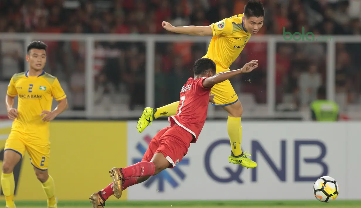 Gaya terbang Ramdani Lestaluhu (tengah) saat berebut bola dengan pemain Song Lam Nghe An FC pada laga Piala AFC 2018 di Stadion Utama GBK, Senayan, Jakarta, (13/3/2018). Persija Jakarta menang 1-0. (Bola.com/Nick Hanoatubun)