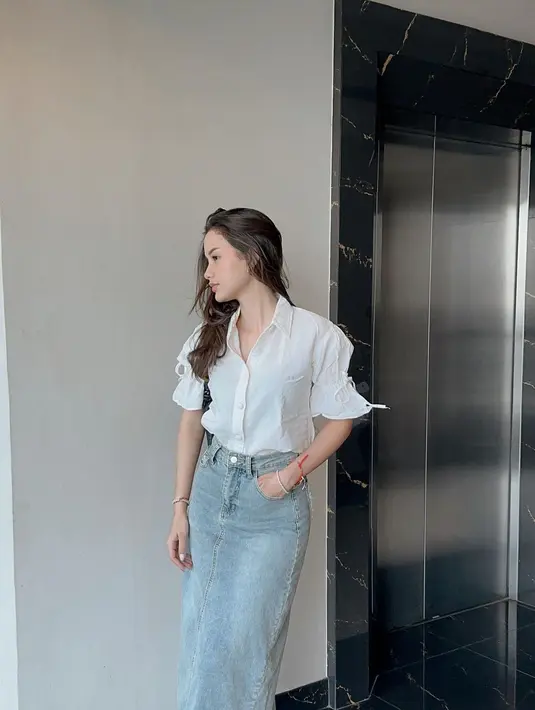 Sarah Menzel tampil chic mengenakan atasan berkerah berwarna putih dipadunya mengenakan denim midi skirt. [Foto: Instagram/ssarah_menzel]