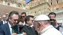 Paus Fransiskus menerima jersey dari presiden tim Chapecoense, Plinio Davide De Nes Filho di Vatikan (30/8). Pertandingan tersebut merupakan pertandingan amal untuk mengumpulkan dana bagi tim Chapecoense. (AP Photo / Andrew Medichini)