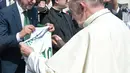 Paus Fransiskus menerima jersey dari presiden tim Chapecoense, Plinio Davide De Nes Filho di Vatikan (30/8). Pertandingan tersebut merupakan pertandingan amal untuk mengumpulkan dana bagi tim Chapecoense. (AP Photo / Andrew Medichini)