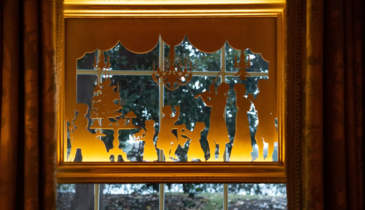 Hiasan Natal tergantung di jendela terlihat selama pratinjau dekorasi liburan 2018 di Gedung Putih, Washington DC, Senin (26/11). Tema dekorasi yang diangkat tahun 2018 ini adalah 'American Treasures'. (NICHOLAS KAMM / AFP)