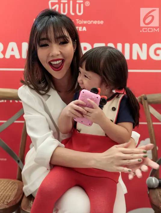 Tawa selebritas Gisella Anastasia bersama sang anak Gempita Nora Marten saat menghadiri pembukaan stan produk minuman di Jakarta, Jumat (23/3). Gisel mengaku sedih jika bekerja tidak dengan Gempi. (Liputan6.com/Faizal Fanani)