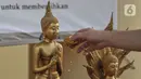 Jemaat menyiramkan air suci pada patung Buddha saat peringatan Tri Suci Waisak 2565 BE di Vihara Hemadhiro Mettavati, Cengkareng, Jakarta Barat, Rabu (26/5/2021). (merdeka.com/Iqbal S. Nugroho)