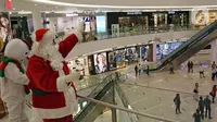 Petugas yang mengenakan kostum Sinterklas menyapa pengunjung di Senayan City Mall, Jakarta, Jumat (25/12/2020). Kegiatan tersebut bertujuan untuk melengkapi kebahagiaan Natal tahun 2020. (Liputan6.com/Herman Zakharia)