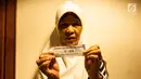 Warga menunjukan undian Rumah Susun di Balai Kota, Jakarta, Senin (26/5). Mereka yang diundang untuk mengikuti pengundian hari ini adalah warga Bukit Duri, yang akan dipindahkan ke Rusun Cakung Barat. (Liputan6.com/Gempur M Surya)