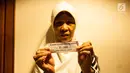 Warga menunjukan undian Rumah Susun di Balai Kota, Jakarta, Senin (26/5). Mereka yang diundang untuk mengikuti pengundian hari ini adalah warga Bukit Duri, yang akan dipindahkan ke Rusun Cakung Barat. (Liputan6.com/Gempur M Surya)