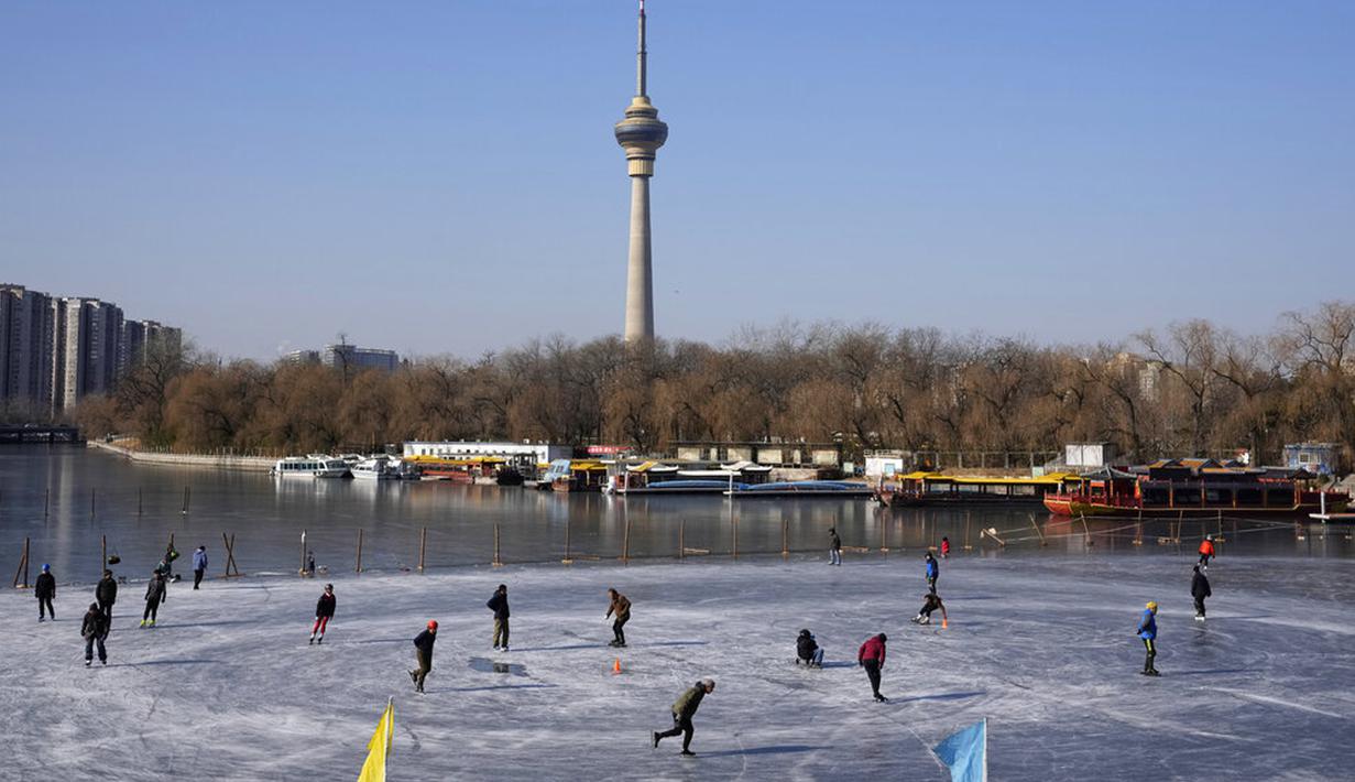 Warga berseluncur di danau beku di Beijing, China, Selasa (11/1/2022). Beijing dalam siaga tinggi menjelang Olimpiade Musim Dingin saat China mengunci kota ketiga di tempat lain akibat COVID-19. (AP Photo/Ng Han Guan)