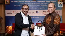 Ketua Umum Asosiasi Internet of Things Indonesia (ASIOTI), Teguh Prasetya (kiri) memberikan produk UMKM kepada Direktur Standardisasi Perangkat Pos dan Informatika, Direktorat Jenderal Sumber Daya dan Perangkat Pos dan Informatika (SDPPI), Kementerian Kominfo Mulyadi (kanan) pada Seminar Solusi Internet of Things untuk Usaha Mikro, Kecil, dan Menengah (UMKM) di Yogyakarta, Rabu (08/06/2021). (Liputan6.com/HO/Alwi)
