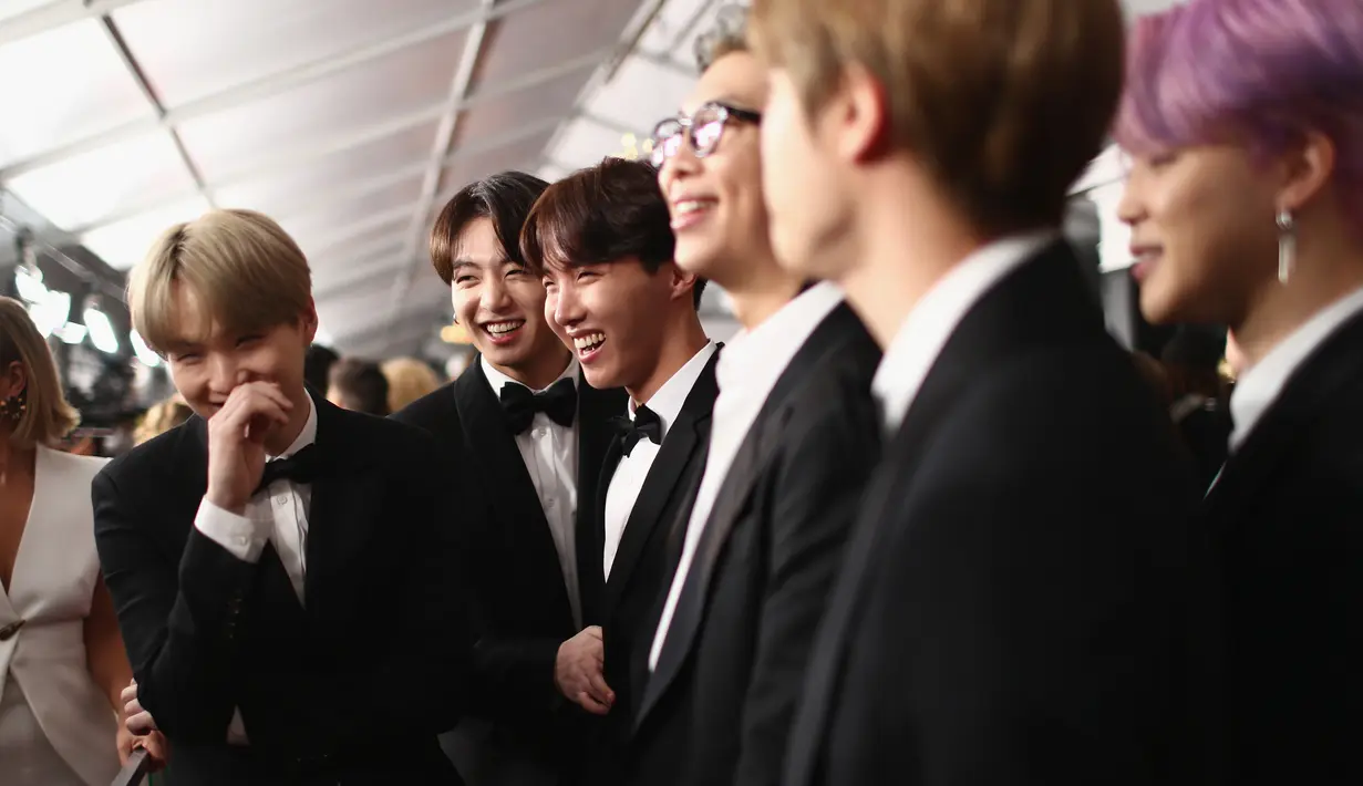 Boyband Korea Selatan, Bangtan Boys alias BTS setibanya di karpet merah perhelatan Grammy Awards 2019 di Staples Center, Los Angeles, Minggu (10/2). Member BTS tampil matching memakai tuksedo hitam, gaya klasik ala Amerika. (Rich Fury/Getty Images/AFP)