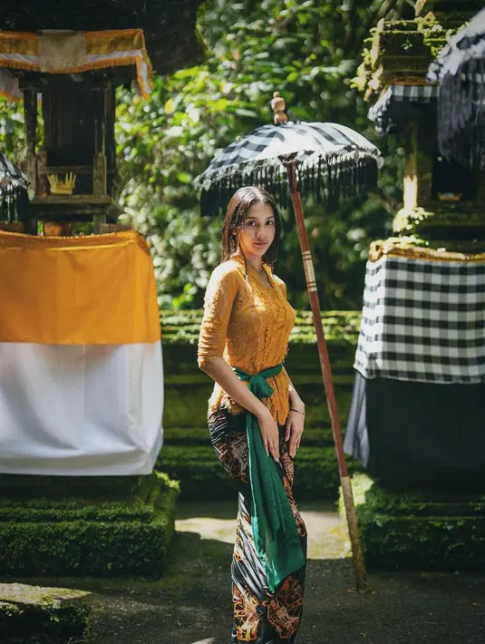 Anya Geraldine tak jarang menampilkan dirinya dalam balutan kebaya Bali. Cantik dibalut kebaya berwarna mustard, Anya memadukannya dengan kain batik cokelat dan selendang hijau yang serasi. Foto: Instagram.