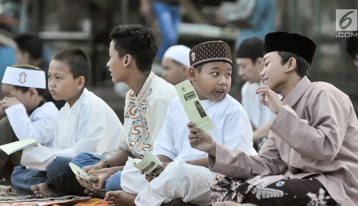 Sejumlah anak berbincang saat mendengarkan khotbah usai melaksanakan salat Idul Fitri 1438 H di kawasan Jatinegara, Jakarta, Minggu (25/7). Ruas Jalan Jatinegara Barat disulap menjadi tempat pelaksanaan salat Ied. (Liputan6.com/Yoppy Renato)