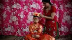 Dewi Hidup, Kumari Unikia Bajracharya (duduk) saat dirias oleh ibunya untuk menghadiri festival untuk Rato Machhindranath di Lalitpur, Nepal, Selasa (10/5). Kumari dianggap reinkarnasi dari dewi-dewi yang hidup di zaman dahulu. (REUTERS/Navesh Chitrakar)
