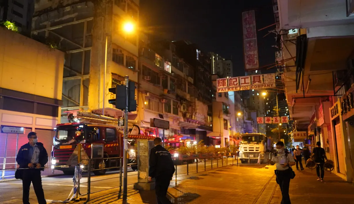 Petugas pemadam kebakaran dan polisi menyelidiki lokasi kebakaran di Hong Kong, China selatan (15/11/2020). Sebanyak tujuh orang tewas dan lebih dari 10 lainnya terluka setelah kebakaran melalap sebuah gedung apartemen di Hong Kong pada Minggu (15/11) malam, menurut kepolisian. (Xinhua/Lui Siu Wai)