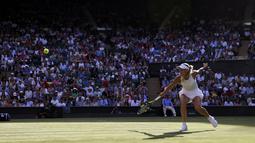 Aksi Caroline Wozniacki saat mengembalikan bola ke arah Timea Babos pada laga tunggal putri Wimbledon 2017 di Wimbledon Tennis Championships, London, (4/7/2017). Wozniacki menang 6-4, 4-6, 6-1. (AP/Alastair Grant)