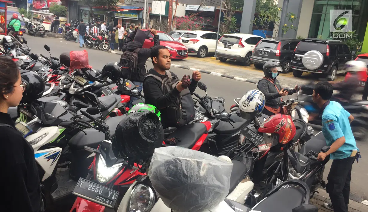 Petugas memarkirkan kendaraan secara manual di sepanjang Jalan Sabang, Jakarta, Jumat (15/12). Karena berakhirnya kontrak, penarikan biaya parkir di 3 wilayah di Jakarta kembali dilakukan secara manual. (Liputan6.com/Immanuel Antonius)