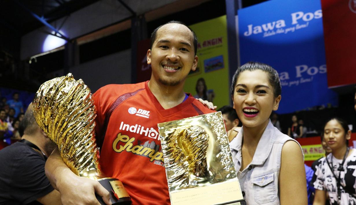 Salah satu bintang Satria Muda Britama,  Arki Dikania Wisnu berpose dengan trofi juara ditemani calon istrinya yang seorang presenter TV, Hilyani Hidranto. (Bola.com/Arief Bagus)