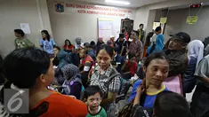 Warga menunggu untuk mendaftarkan akte kelahiran di Sudin Kependudukan dan Catatan Sipil Kotamadya, Jakarta Timur, Senin (28/12). Meskipun antre, namun ratusan warga tetap antusias mendaftarkan akte kelahiran serta e-KTP. (Liputan6.com/Immnuel Antonius) 