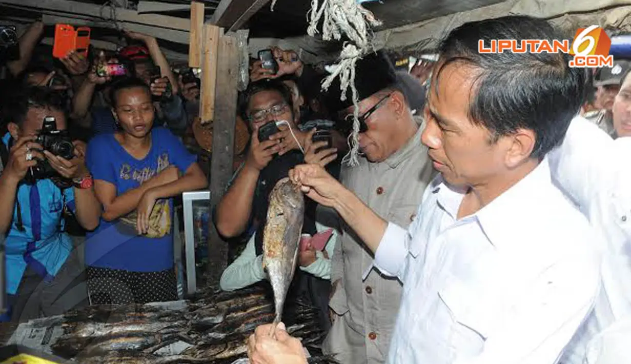 Beginilah ekspresi Jokowi saat akan membeli ikan asap kegemarannya. Ia tampak teliti mengamati setiap tubuh ikan asap yang akan dipilih (Liputan6.com/Herman Zakharia)