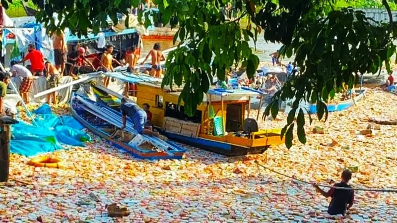 Ribuan bungkus mie instan mengambang di Sungai Siak setelah kapal karam di pelabuhan rakyat.