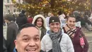 Di Vienna Liza mengenakan jaket maroon dipadukan syal coklat kotak-kotak. Putrinya mengenakan turtleneck putih serasi dengan topi berbulunya. [@lizanataliaofficial]