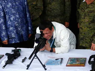 Presiden Filipina Rodrigo Duterte mencoba senapan sniper CS / LR4A buatan China di Clark Airbase di Filipina (28/6). Bantuan militer tersebut akan digunakan untuk melawan ancaman terorisme dan pembajakan dari kelompok militan. (AP Photo/Bullit Marquez)