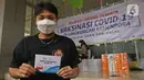 Atlet Bulutangkis Apriyani Rahayu menunjukkan kartu vaksin di Rumah Sakit Olahraga Nasional, Jakarta, Jumat (12/3/2021). Kemenpora bersama Kemenkes melakukan vaksinasi COVID-19 dosis ke-2 kepada insan olah raga nasional dengan menyasar 820 orang secara bertahap. (Liputan6.com/Herman Zakharia)