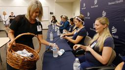 CEO Banner Desert Medical Center, Laura Robertson (kiri) membagikan pakaian bayi kepa 16 suster di bagian gawat darurat yang sedang hamil bersamaan selama konferensi pers di sebuah rumah sakit di Mesa, Arizona, 17 Agustus 2018. (AP/Ross D. Franklin)