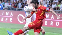 Gelandang bertahan Makedonia Dusko Trajkovski (merah) dihadang winger Slowakia, Vladimir Weiss. (Bola.com/Reza Khomaini)