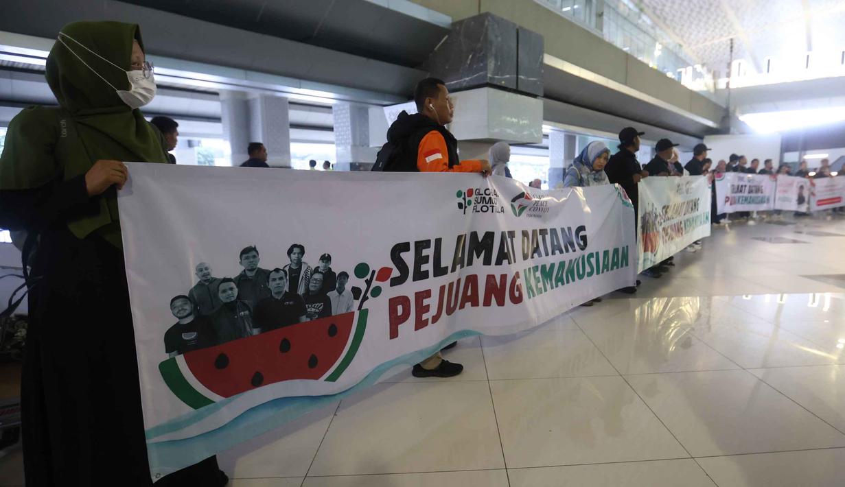 Sejumlah relawan bersiap menyambut kembalinya aktivis dan jurnalis yang tergabung dalam misi Global Sumud Flotilla 2.0 di pintu kedatangan Terminal 3 Bandara Internasional Soekarno-Hatta pada Minggu (24/5/2026) sore. (Kapanlagi.com/Budy Santoso)