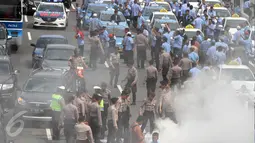 Aparat kepolisian memadamkan aksi bakar ban yang oleh sopir taksi yang melakukan demo di tol dalam kota, Mampang, Jakarta, Selasa (22/3). Tak hanya itu, para sopir taksi juga memblokade jalan sehingga kendaraan tak bisa melintas (Liputan6.com/Johan Tallo)