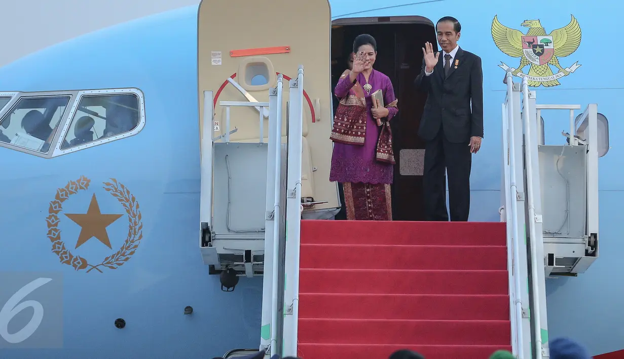 Presiden Jokowi dan Istri melambaikan tangan sebelum memasuki pesawat di Bandara Halim Perdana Kusuma, Jakarta,(24/10/2015). Tujuan utama Jokowi adalah meningkatkan hubungan bilateral, terutama investasi dan perdagangan. (Liputran6.com/Faizal Fanani)