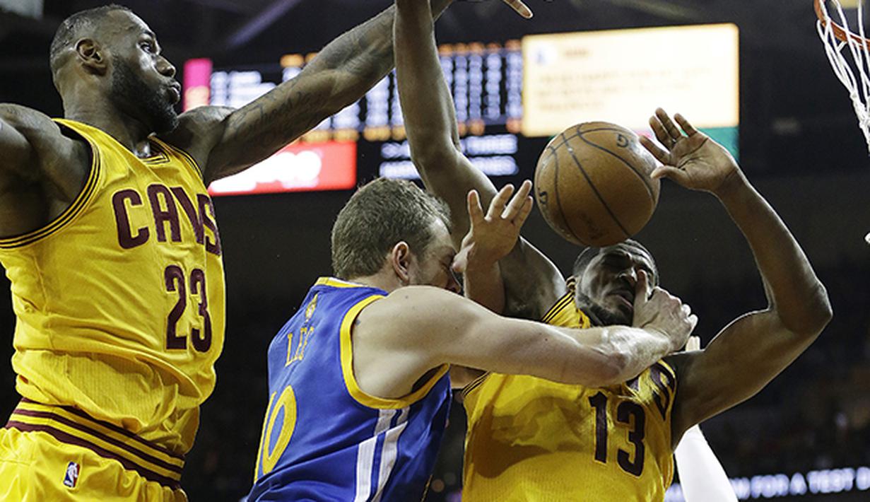 David Lee (10) asal Golden State Warriors dijaga ketat oleh LeBron James (kiri) dan Tristan Thompson dari Cleveland Cavaliers. (AP Photo/Tony Dejak)