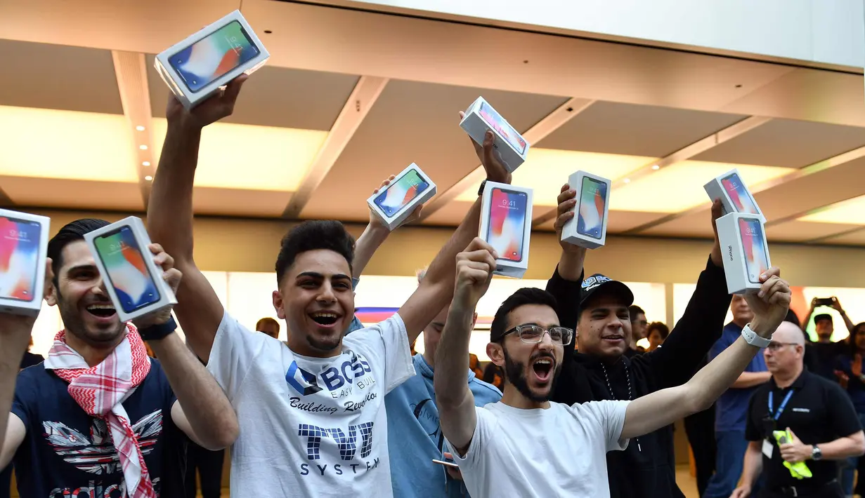 Pelanggan pertama menunjukkan iPhone X setelah ia membelinya di showroom Apple di Sydney, Australia (3/11). Apple iPhone X mulai dijual di Australia dengan antrian panjang di luar toko Apple. (AFP Photo/Saeed Khan)