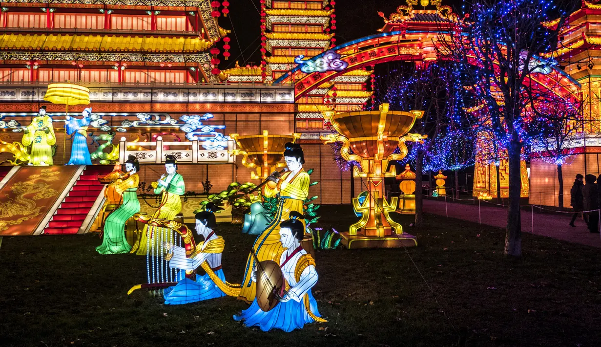 Pengunjung berdiri dekat lentera istana raksasa dalam Festival Lentera Gaillac di Taman Foucaud, Gaillac, Prancis, Rabu (12/12). Festival ini juga menandai berakhirnya perayaan untuk periode Tahun Baru China. (ERIC CABANIS/AFP)