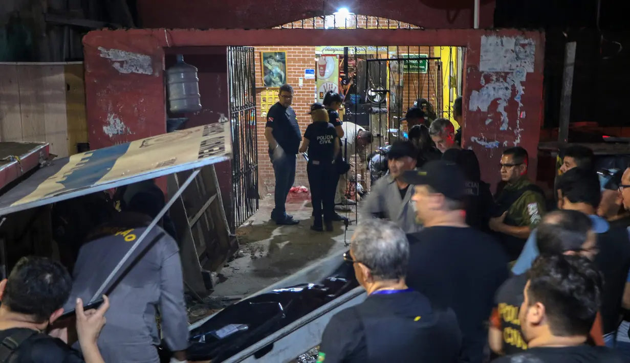 Sejumlah petugas saat mengevakuasi korban penembakan massal di sebuah bar di kota Belm, negara bagian utara Par, Brazil (19/5/2019). Sebanyak 11 orang dilaporkan tewas dalam serangan yang dilakukan 7 pria bersenjata tersebut. (Claudio Pinheiro/Agencia Panamazonica/AFP)