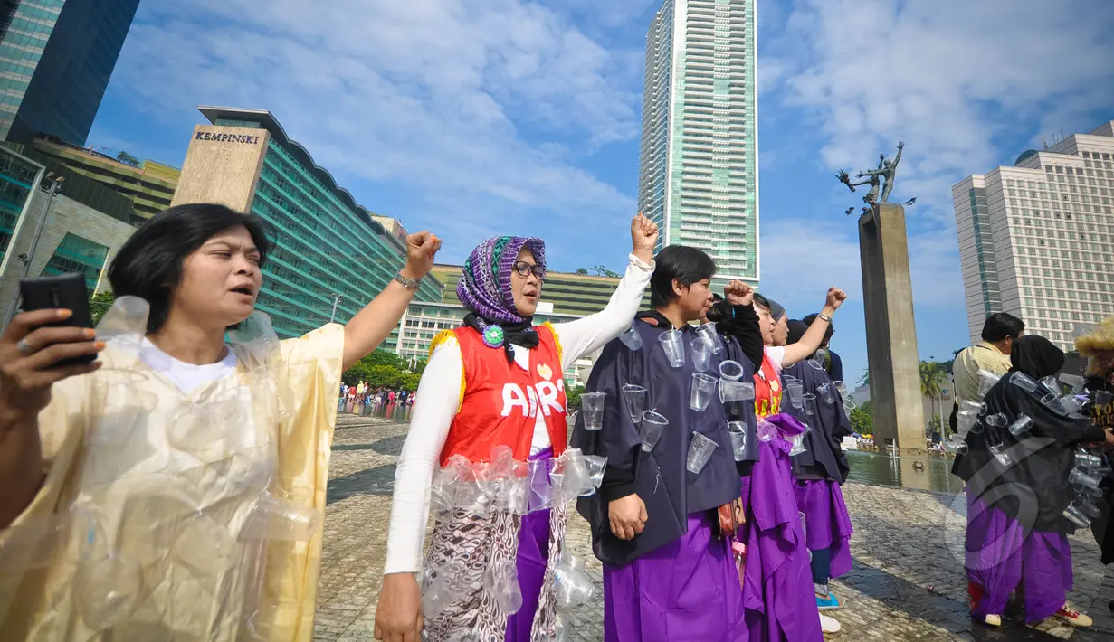 Sejumlah aktivis mengenakan kostum dari sampah plastik air mineral saat menggelar aksi Menolak Swastanisasi Air Jakarta di Bundaran HI, Jakarta, Minggu (22/3/2015). (Liputan6.com/Faizal Fanani)
