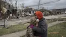 Ibu dan anak berpelukan melihat kondisi kawasan rumah mereka usai dihantam badai di Illinois, AS, Rabu (1/3). Kumpulan badai yang dikenal dengan istilah supercells telah menewaskan dua orang di Illionois (AP Photo/ Zbigniew Bzdak)