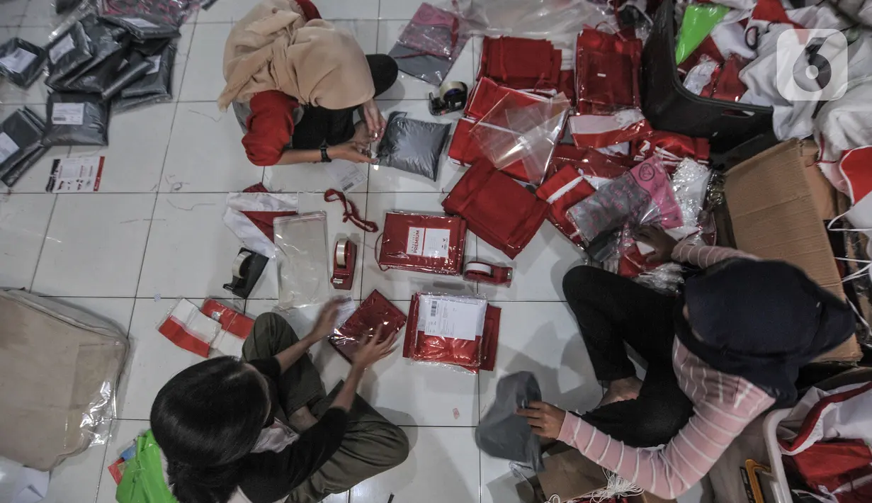 Pekerja mengemas bendera Merah Putih untuk diikirim melalui jasa kurir di industri rumahan benderaindonesia.com, Jakarta, Selasa (3/8/2021). Andri (56) seorang pemilik toko bendera online ini mengaku dalam sehari mampu menjual hingga 100 buah bendera Merah Putih. (merdeka.com/Iqbal S Nugroho)