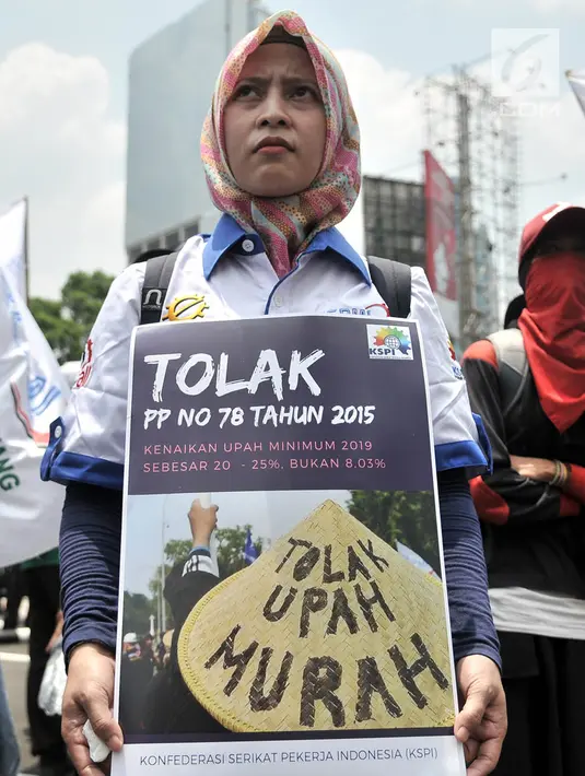 Seorang buruh membawa poster berisi penolakan terhadap upah murah saat menggelar unjuk rasa di depan Gedung Kementerian Ketenagakerjaan, Jakarta, Rabu (24/10). (Merdeka.com/Iqbal S. Nugroho)