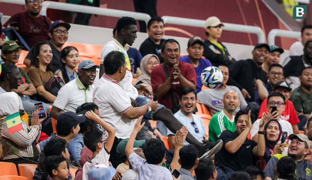 Seorang suporter Senegal memperlihatkan kemampuannya dalam melakukan juggling pada laga 16 Besar Piala Dunia U-17 2023 antara Timnas Prancis U-17 melawan Timnas Senegal U-17 yang berlangsung di Jakarta Internetional Stadium (JIS), Jakarta, Rabu (22/11/2023). (Bola.com/Bagaskara Lazuardi)