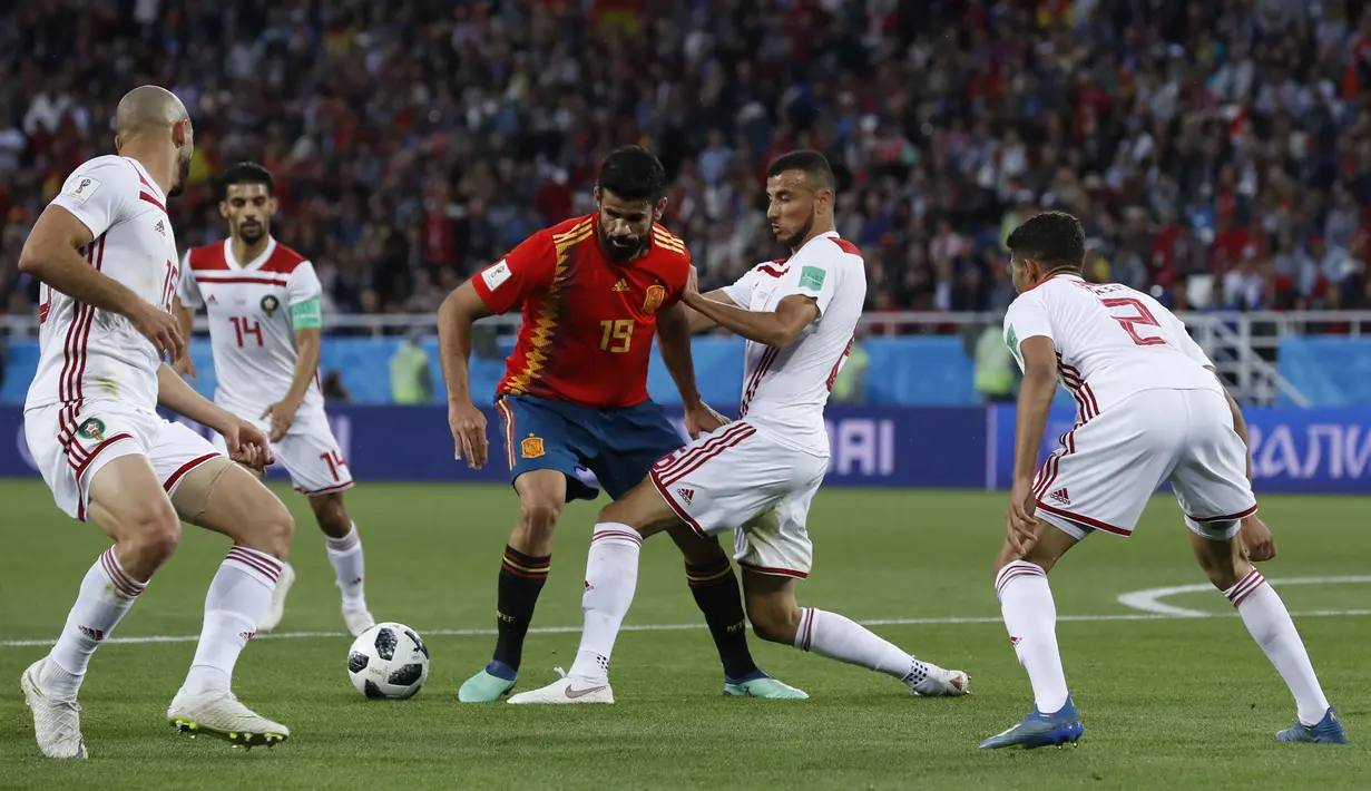 Striker Spanyol, Diego Costa, berusaha melewati kepungan pemain Maroko pada laga grup B Piala Dunia di Stadion Kaliningrad, Kaliningrad, Senin (25/6/2018). Kedua negara bermain imbang 2-2. (AP/Manu Fernandez)
