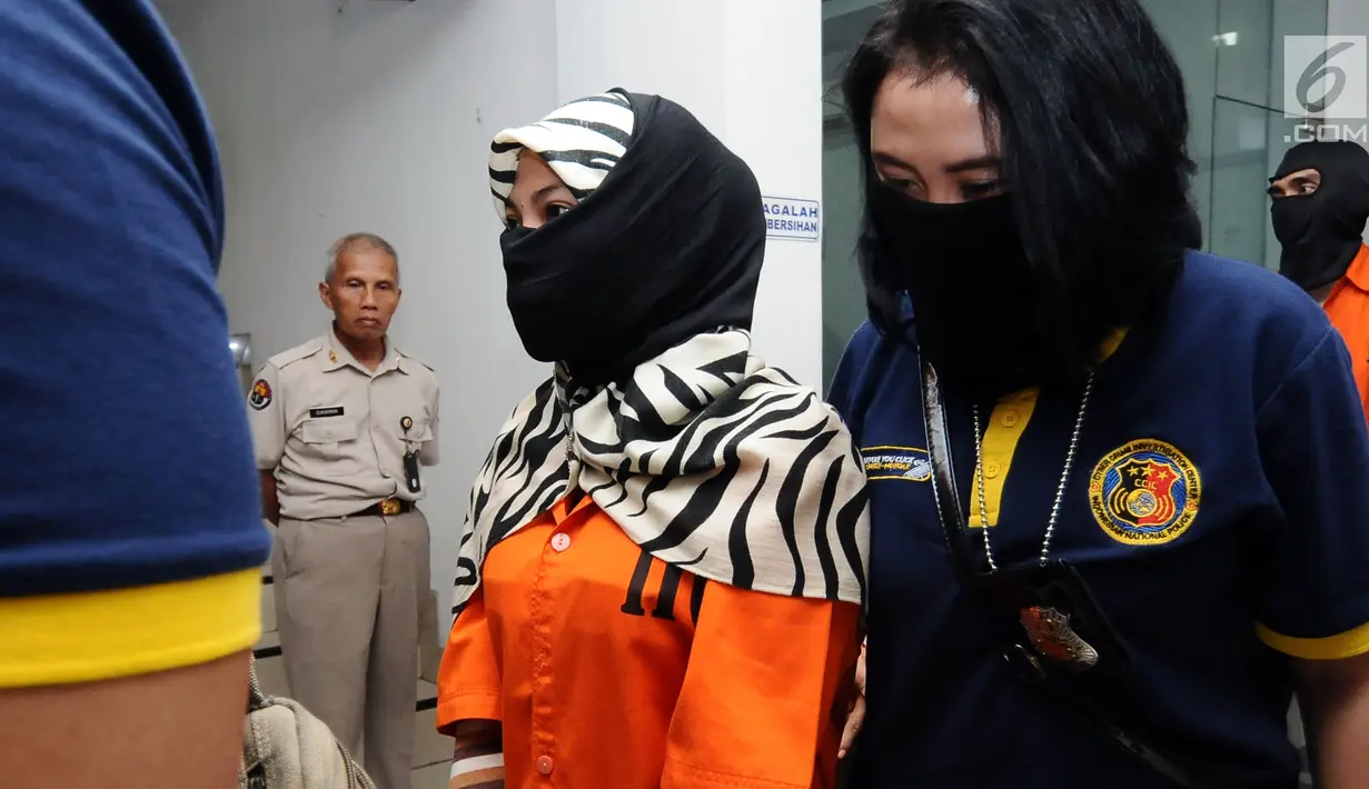 Salah satu tersangka kasus penyebaran ujaran bernada kebencian lewat internet digiring polisi usai rilis di Jakarta, Rabu (23/8). Tiga tersangka masuk dalam satu kelompok. (Liputan6.com/Helmi Fithriansyah)