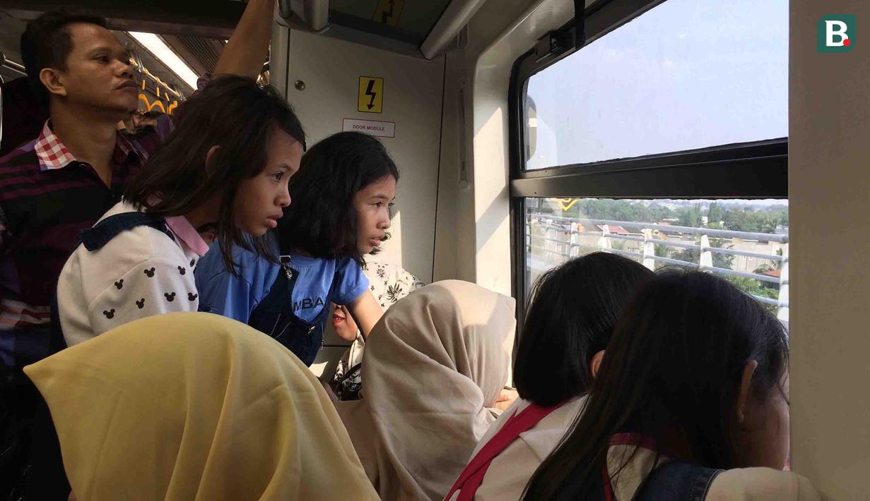 Para penumpang menikmati pemandangan saat menaiki kereta LRT di Palembang, Sumatra Selatan, Minggu (5/7/2018). LRT ini akan menjadi salah satu solusi transportasi saat Asian Games mendatang. (Bola.com/Reza Bachtiar)