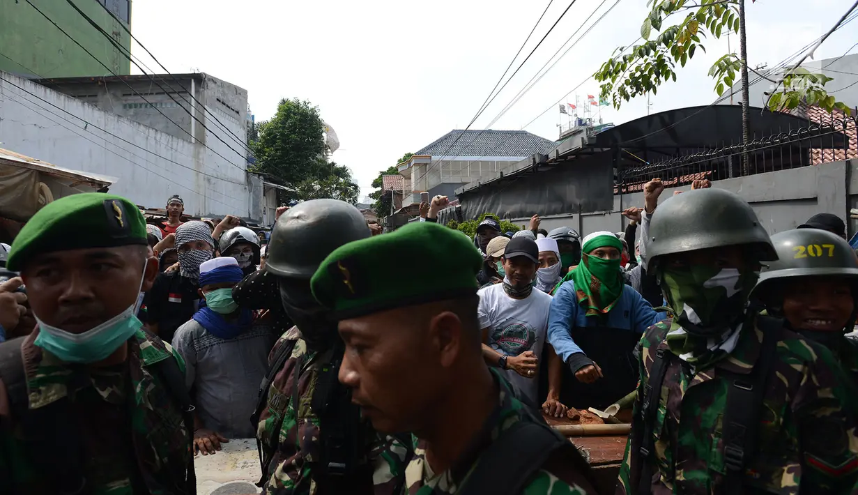 Personel TNI seusai berdiskusi dan rekonsiliasi dengan warga untuk mencegah kerusuhan susulan di Jalan KS Tubun, Petamburan, Jakarta, Rabu (22/5/2019). Aparat keamanan berhasil menghalau massa aksi 22 Mei yang sebelumnya berkumpul di kawasan tersebut. (merdeka.com/Imam Buhori)