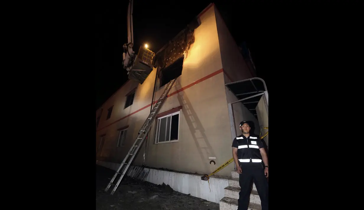 Beberapa bagian rumah sakit terlihat rusak. Tampak petugas keamanan berjaga disekitar lokasi terbakarnya rumah sakit di Jangseong, Korea Selatan, (28/5/2014). (REUTERS/Hyung Min-woo/Yonhap)