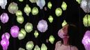 Seorang wanita melihat "Pixel Forest" oleh seniman Swiss Pipilotti Rist, sebuah instalasi seni dari 3000 lampu LED pahatan tangan yang digantung di langit-langit di Tai Kwun di Hong Kong (18/8/2022). (AFP/Isaac Lawrence)