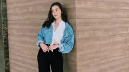 Memadukan busana putih dengan jaket jeans memang tidak pernah salah dan membuat mati gaya. Wanita 22 tahun ini juga memilih makeup natural serta rambut hitam yang dibiarkan terurai. (Liputan6.com/IG/@rantymaria)