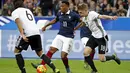 Penyerang Perancis, Anthony Martial (tengah) berusaha melewati bek Jerman, Matthias Ginter pada laga persahabatan di stadion Stade de France, Perancis, (13/11). Perancis menang atas Jerman dengan skor 2-0. (REUTERS/Benoit Tessier)