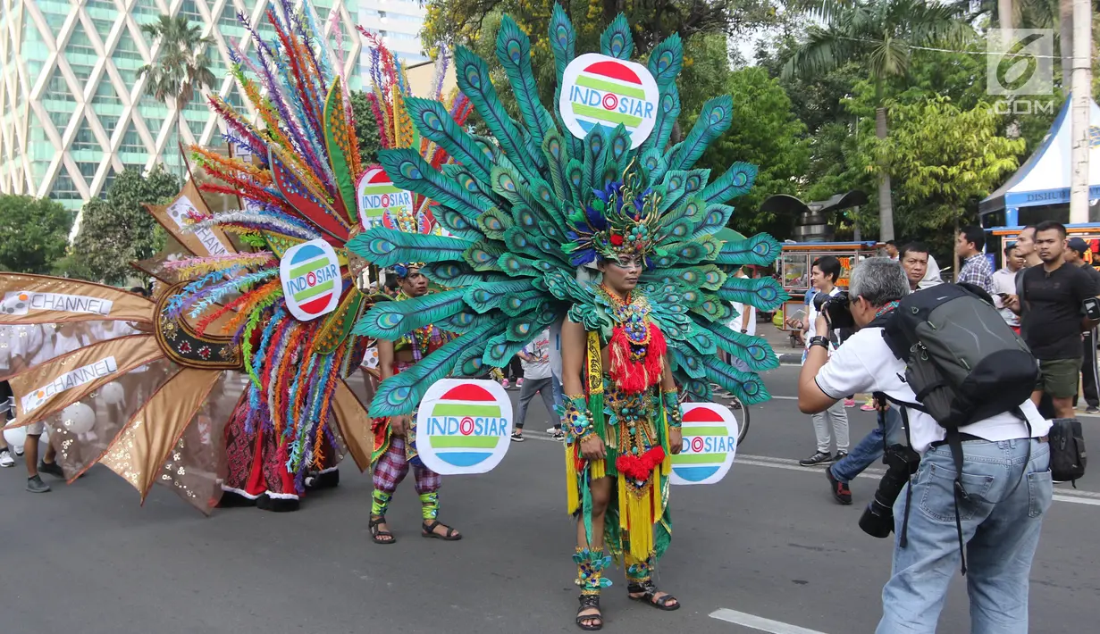 Peserta berkostum Indosiar memeriahkan parade Asian Games 2018 di Jalan Thamrin, Jakarta, Minggu (13/5). Tak hanya dari komunitas, peserta parade ini juga datang dari karyawan PT Elang Mahkota Teknologi (Emtek). (Liputan6.com/Arya Manggala)